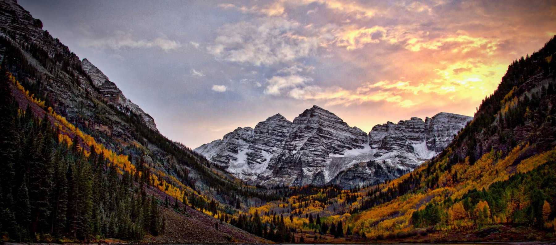 A scenic shot of Colorado mountains with the sun rising