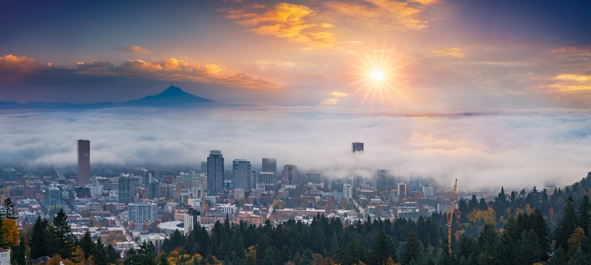 Mt. Hood and Portland downtown with rolling fog and autumn foliage in shining sunrise and colorful clouds