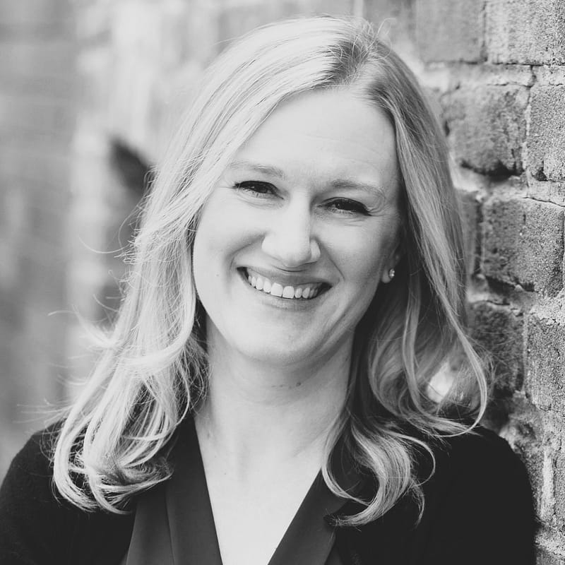 Laura Hays's headshot in black and white in front of a brick wall background.