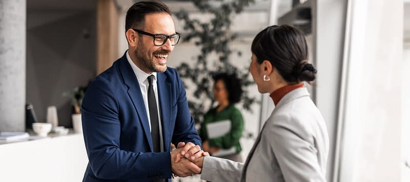 Businessman and businesswoman shaking hands in daylight