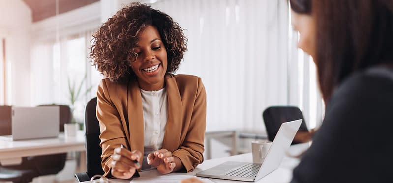 2 Women working at desk in professional environment in daylight