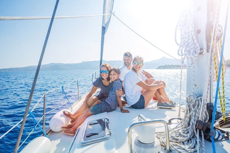Happy family with adorable daughter and son resting on a big yacht