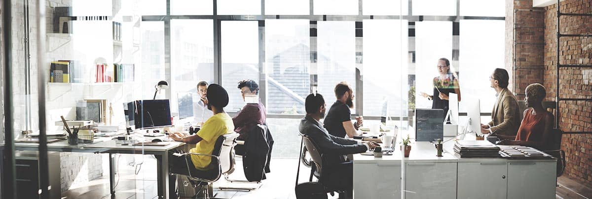 Office workers at desks in a well-lit room