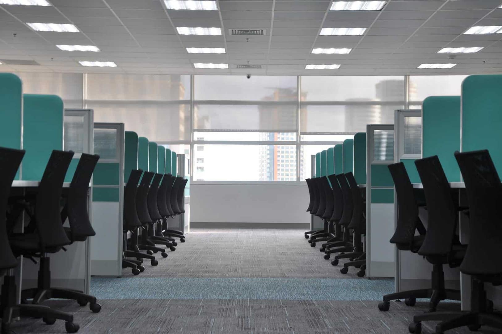 An empty row of cubicles in an office space; employer resources for managing business during COVID-19.