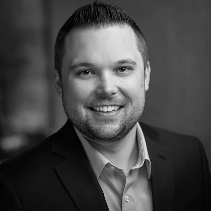 Eric Seifert's headshot in black and white in an indoor office space.