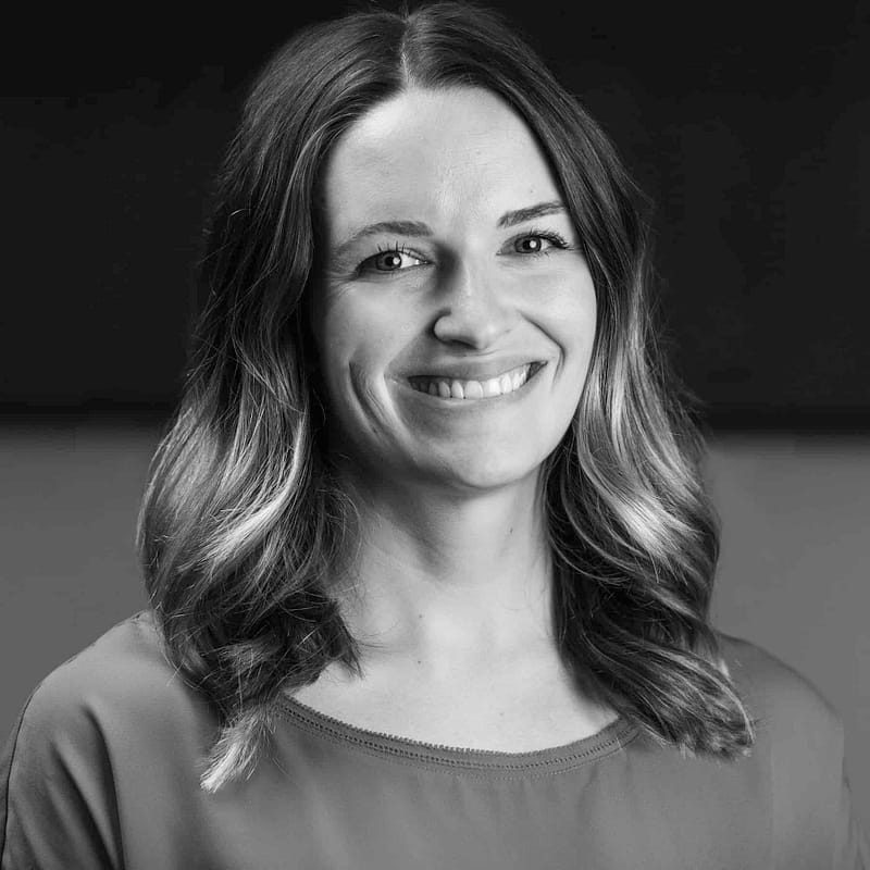 Andrea Waymire headshot in office space in black and white.