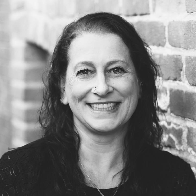 Jessica Brinkley's headshot in black and white in front of a brick wall background.