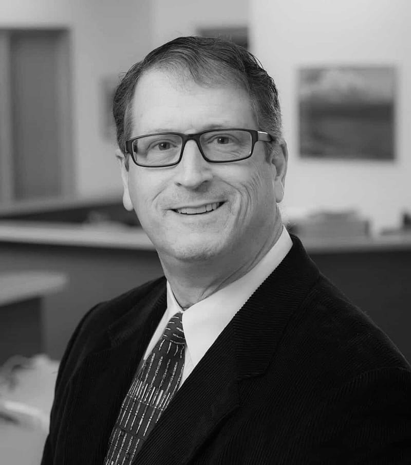 Barry Altman's head shot in black and white in an office space.