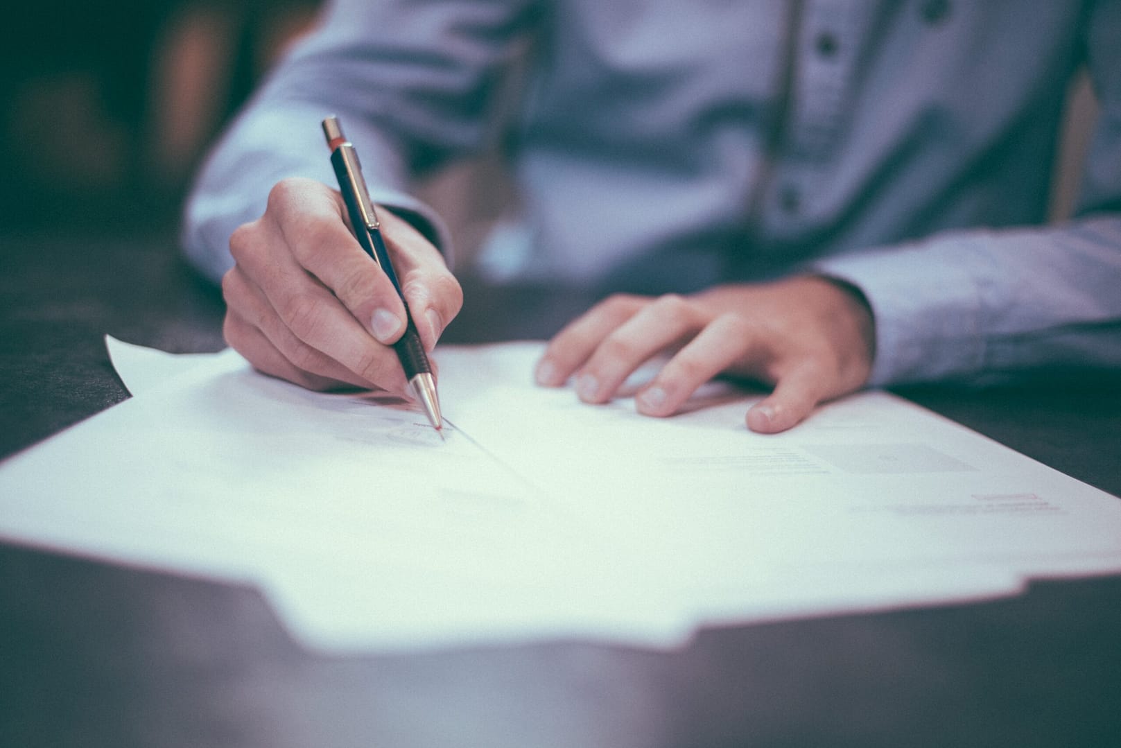 A pair of hands belonging to an M&A advisor drawing up a plan for a client.