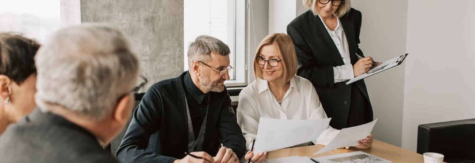 Business owner consult with their M&A advisor at a conference table with financial documents on the table