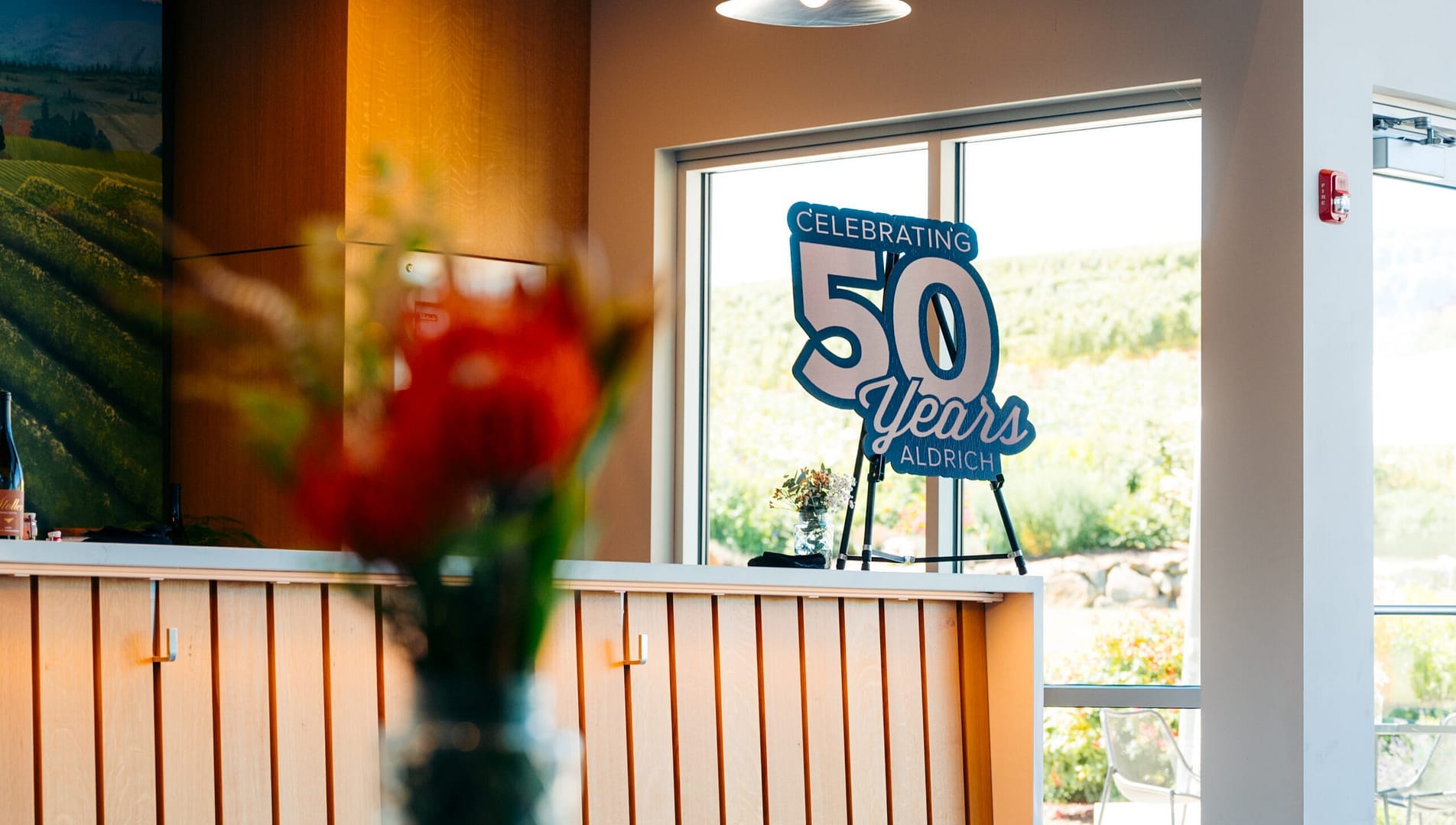 Cardboard cutout of 50 year anniversary icon sitting on an appetizer bar at Aldrich's anniversary event