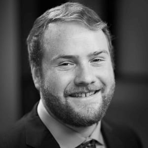 Cole Corrigan's headshot in black and white in office space.