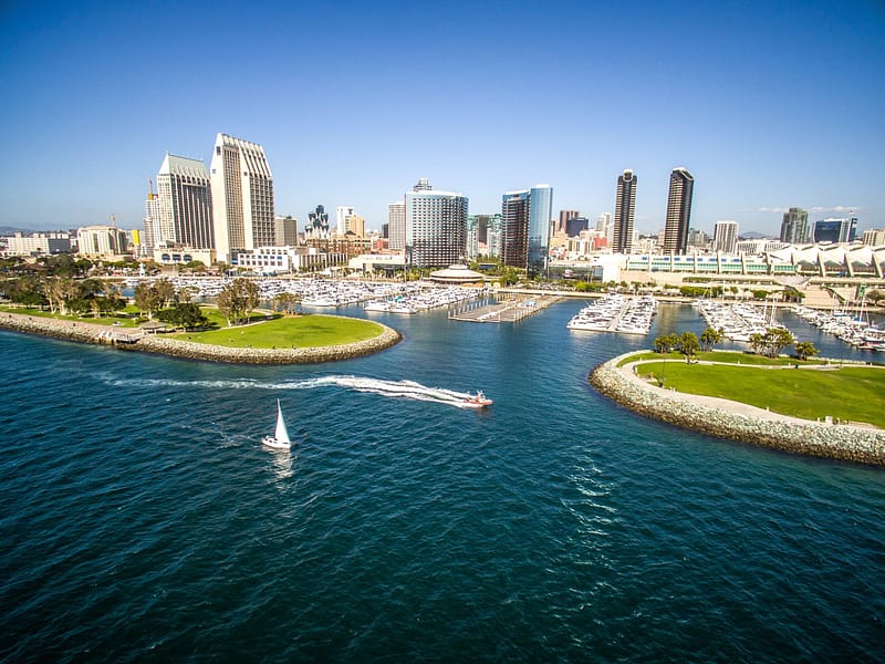 An aerial photo of the water, sail boats, and San Diego's city skyline on a clear day.