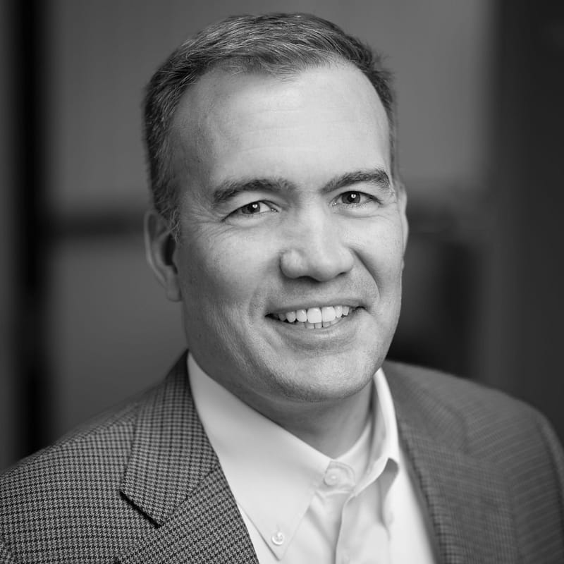 Joe Fitts's headshot in black and white in office space.