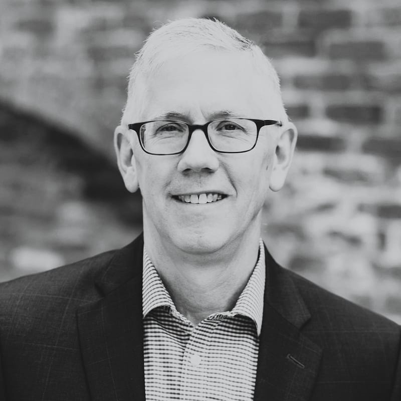 Kevin Sell headshot, outdoor setting, black and white