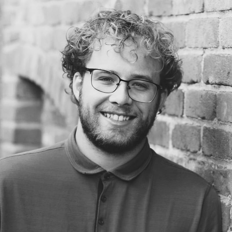 Nate Condon's headshot in black and white in front of a brick wall.