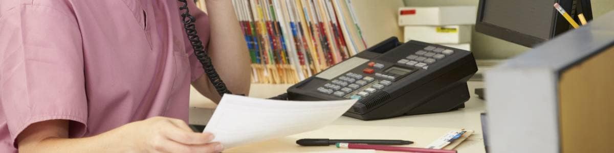 dental office receptionist looking over new dental scripts
