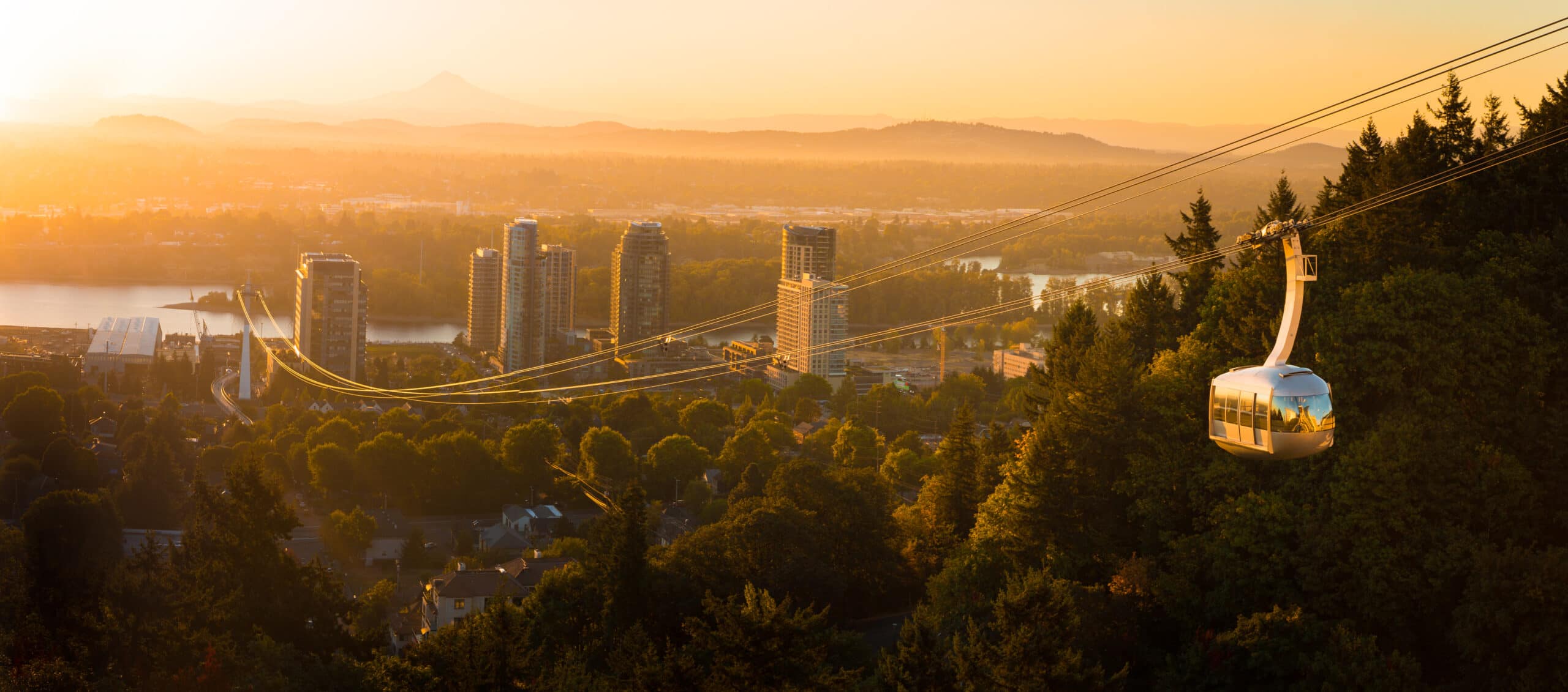 Aerial tram in Portland, Oregon transporting people to and from the hilltop with Oregon Health and Science University (OHSU) and a beautiful view on mount Hood and mount st. Helens