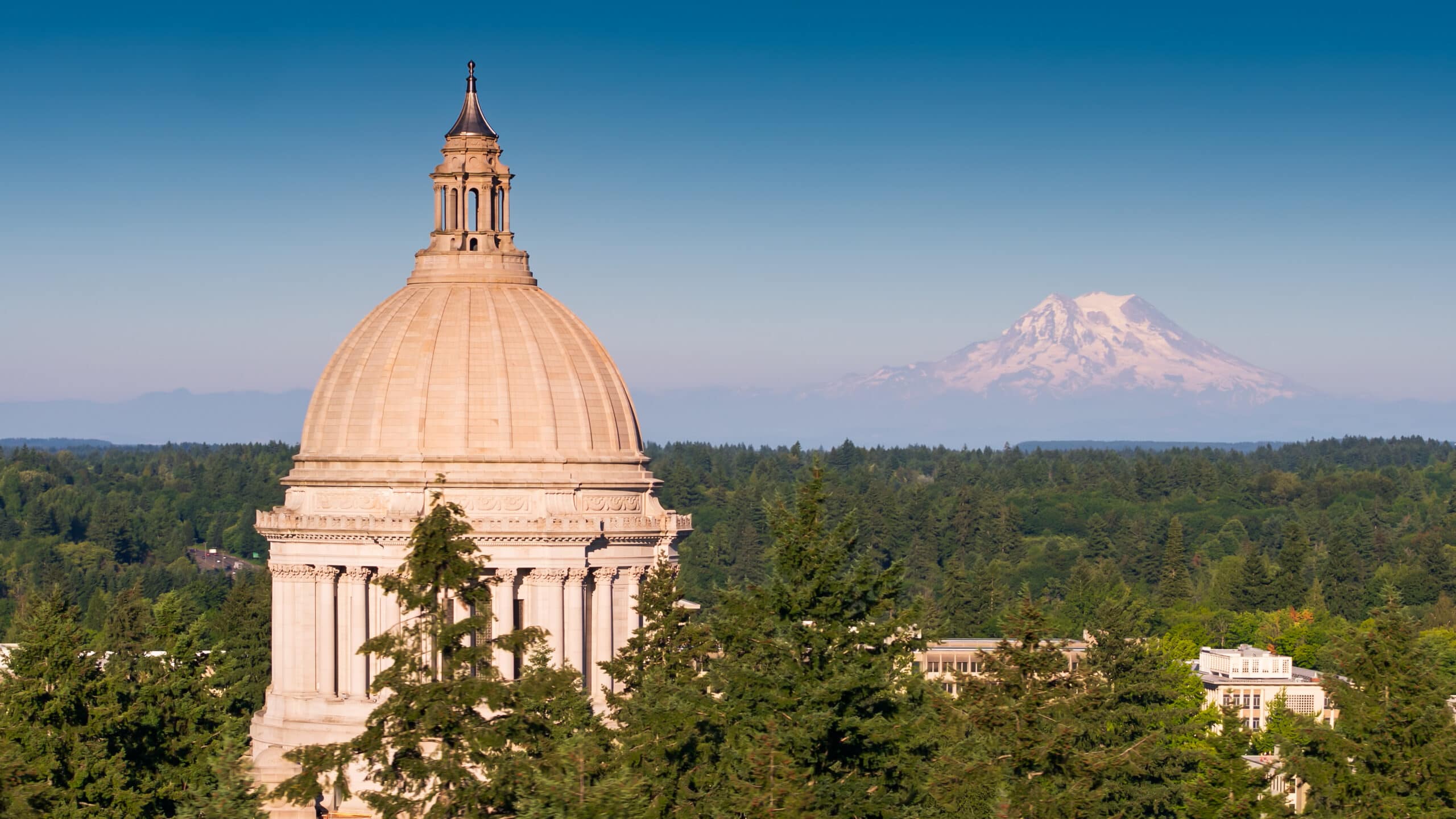 Washington State Capitol Building in daylight with Mount Rainier in distance