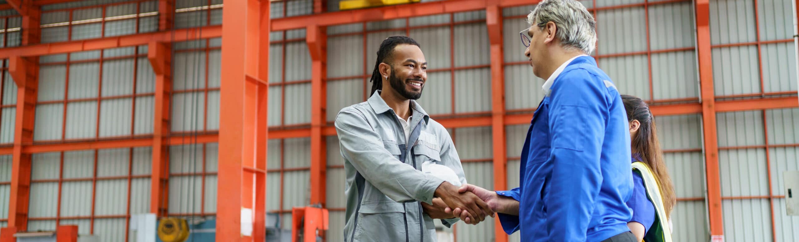 Two men, warehouse, shaking hands, daytime