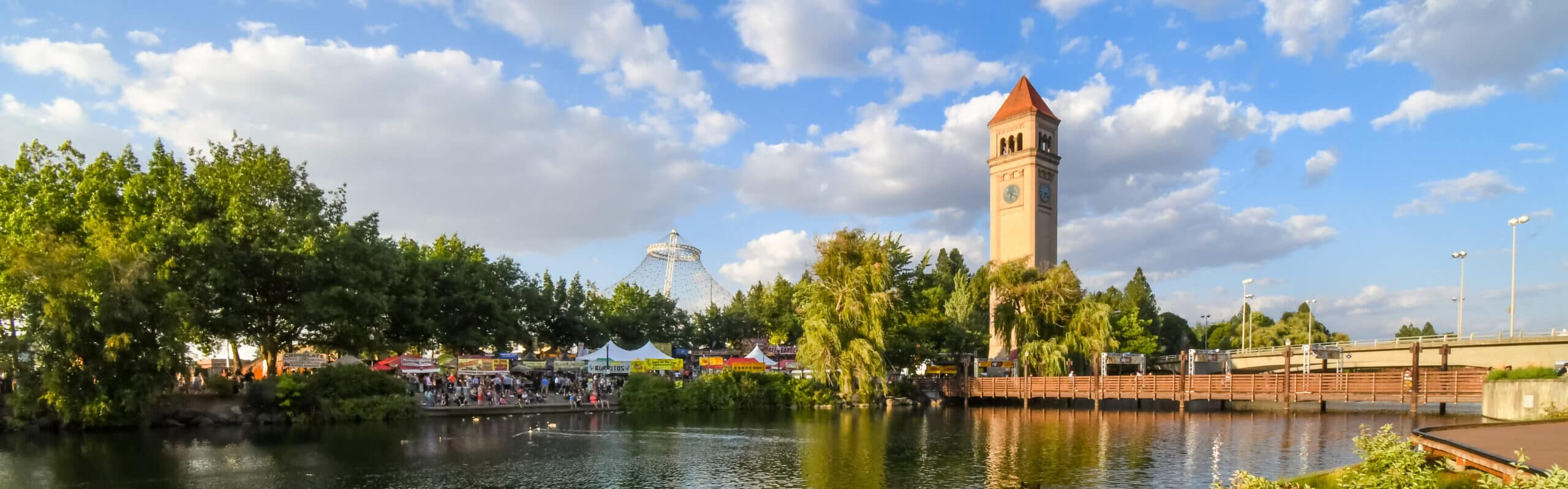 Afternoon view of Riverfront Park along the Spokane river with the clocktower and pavilion in view during an annual festival in Spokane, Washington, USA, where Aldrich is a Top Accounting Firm in the Spokane/Inland Northwest Region for 2026.