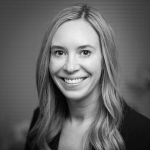 Emily Payment's headshot in black and white in office space.