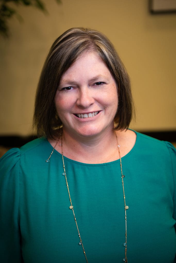 Tracy Allen's headshot in true color in office space.