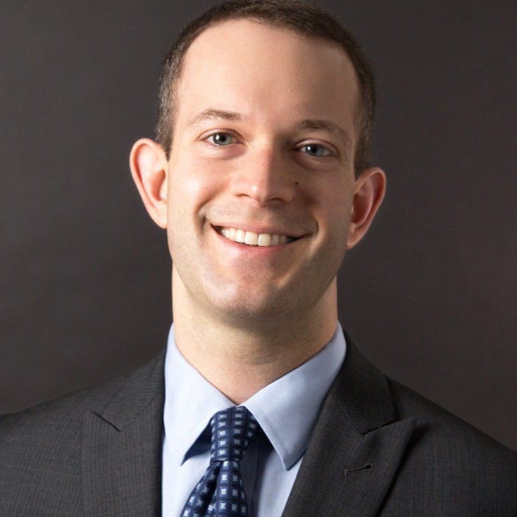Headshot of Schwabe's Batt Bisturis in front of a gray background.