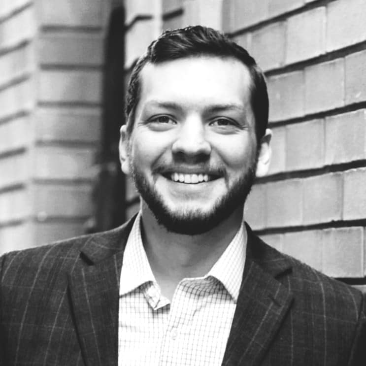 Joshua Johnson's headshot in black and white in outdoor space.