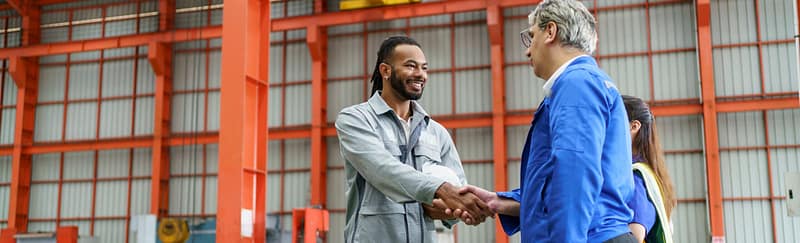 Two men, warehouse, shaking hands, daytime