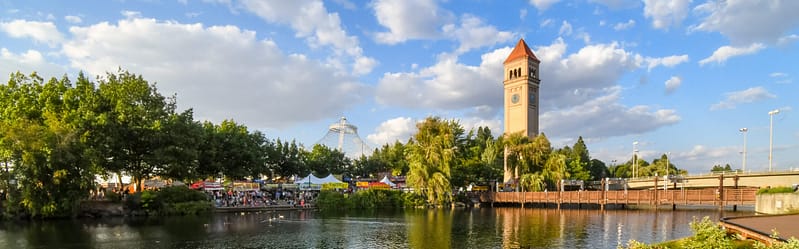 Afternoon view of Riverfront Park along the Spokane river with the clocktower and pavilion in view during an annual festival in Spokane, Washington, USA, where Aldrich is a Top Accounting Firm in the Spokane/Inland Northwest Region for 2026.