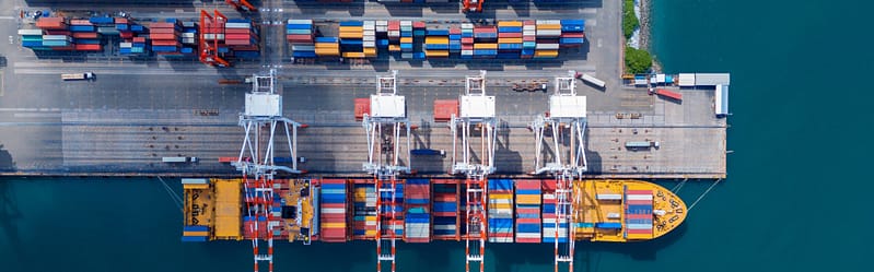 Crane loading cargo container from truck to container ship in the international terminal logistic sea port concept freight shipping by ship. industry transportaion stock photo
