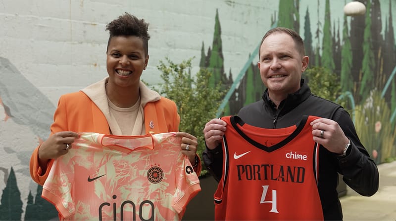 John Lauseng and Karina LeBlanc holding Portland Thorns, and Portland Fire Jerseys