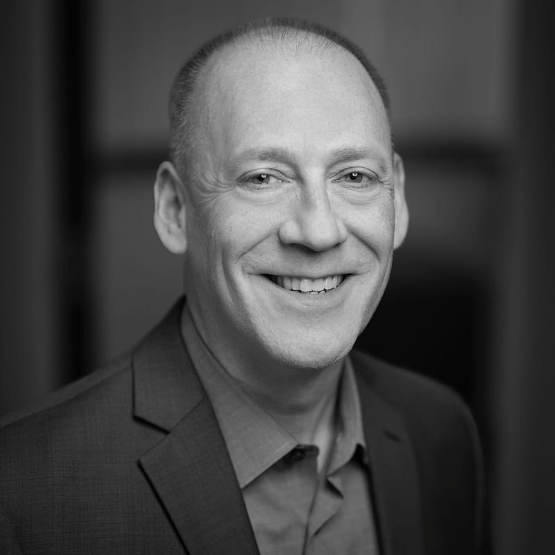 Daryl Knox's headshot in black and white in office space.