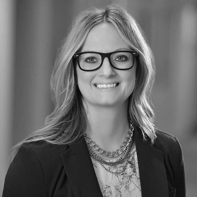 Janelle Hyter's headshot in black and white in office space.