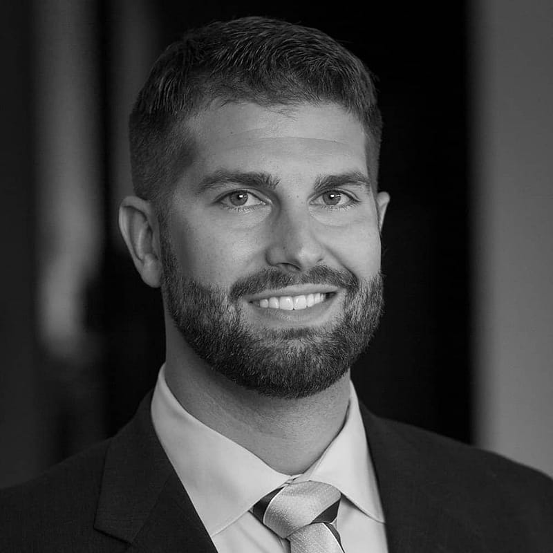 Casey McKillip's headshot in black and white in office space.