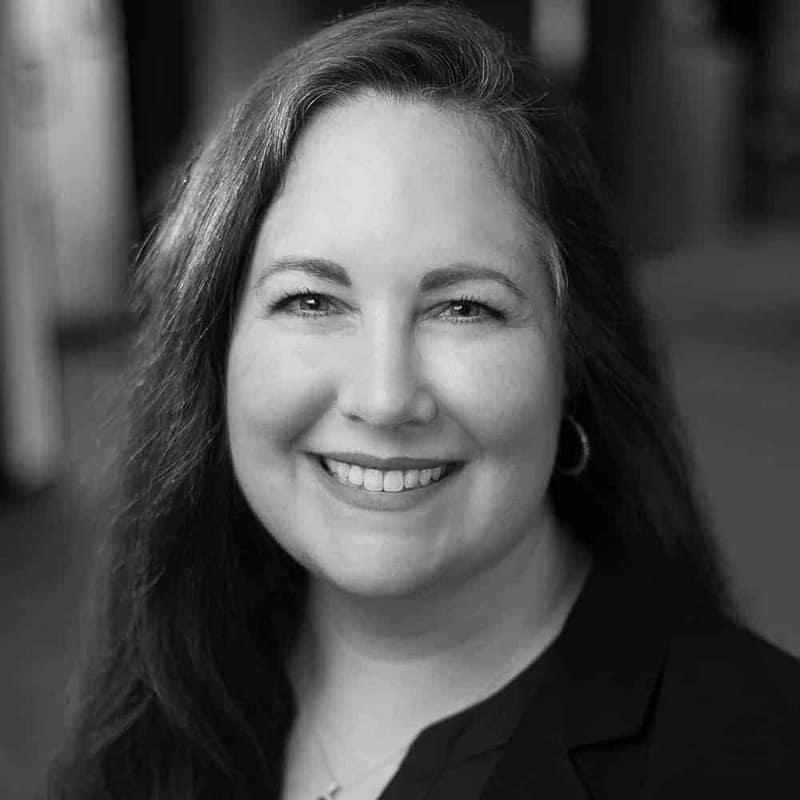 Diana Strassmaier's headshot in black and white in office space.