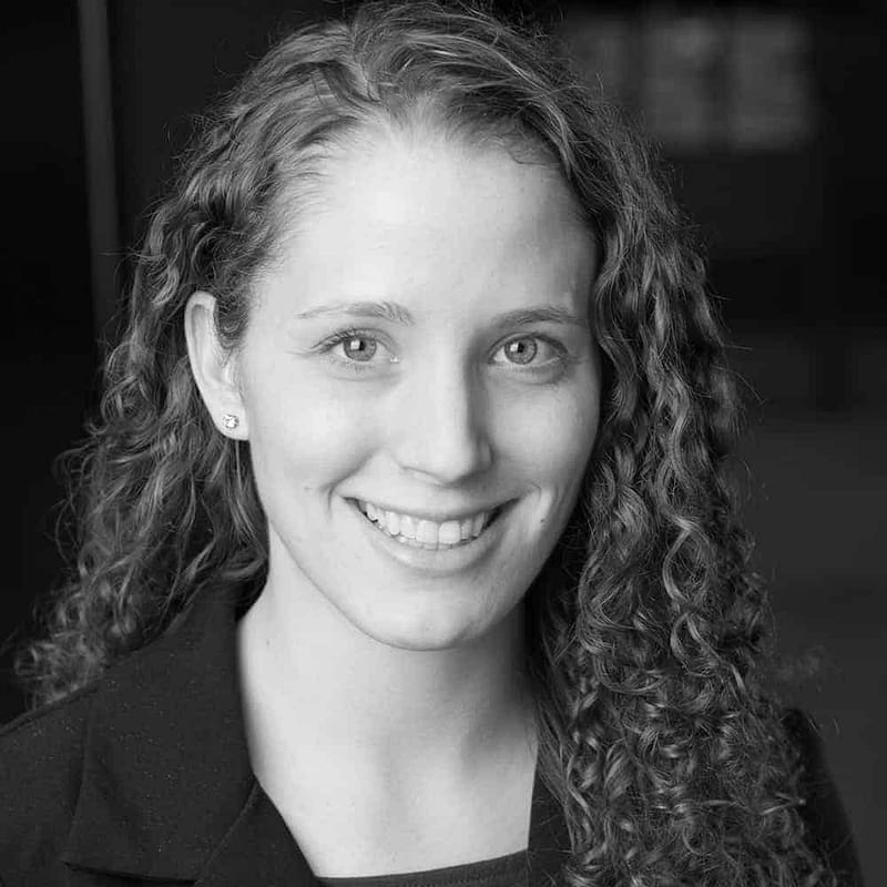 Katie Klarenbach's headshot in black and white in office space.