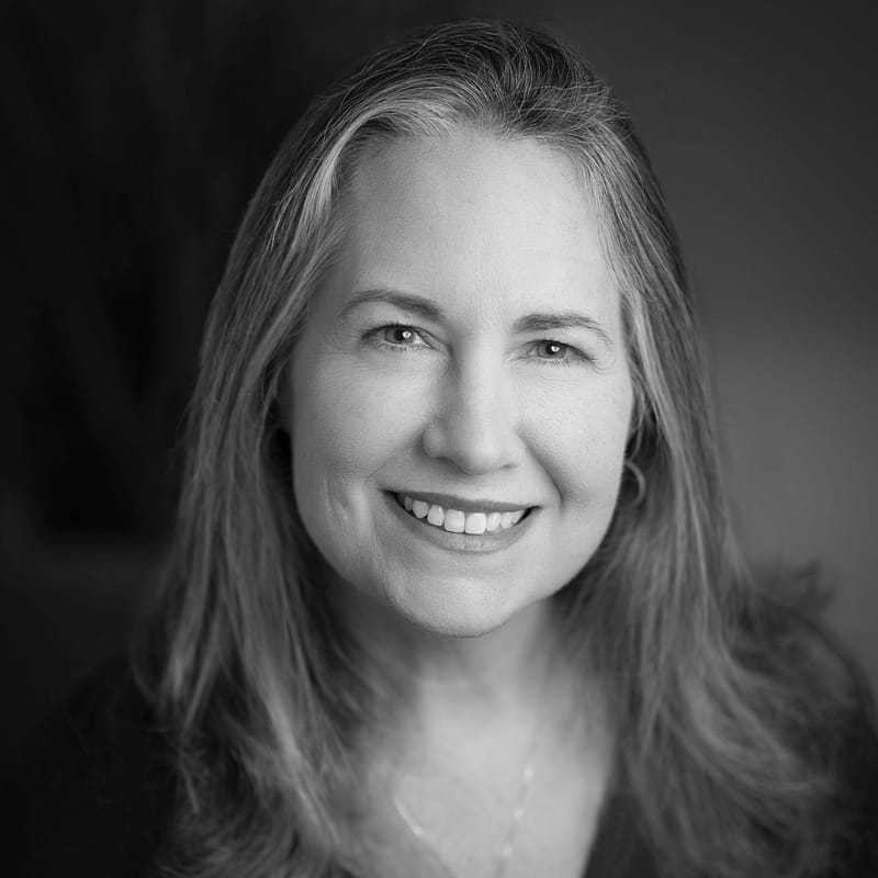 Diana Strassmaier's headshot in black and white in office space.