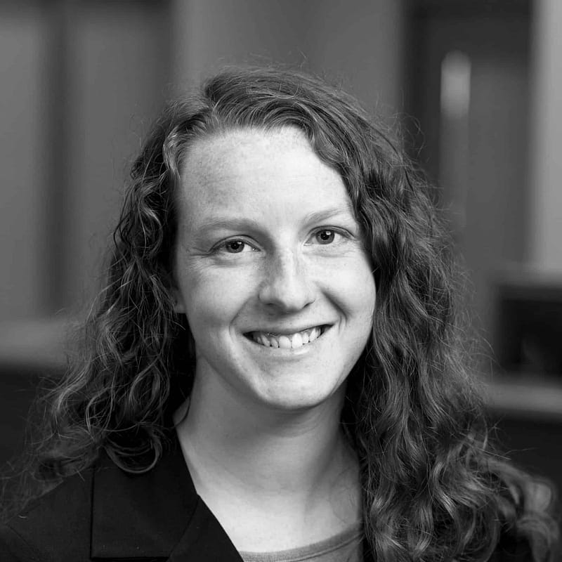 Amber Miller's headshot in black and white in office space.