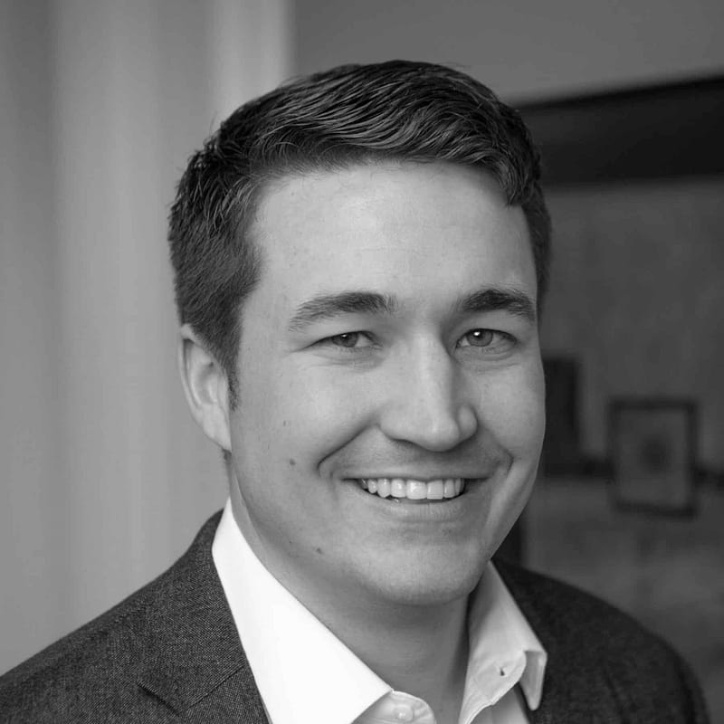 Justin Swartz's headshot in black and white in office space.