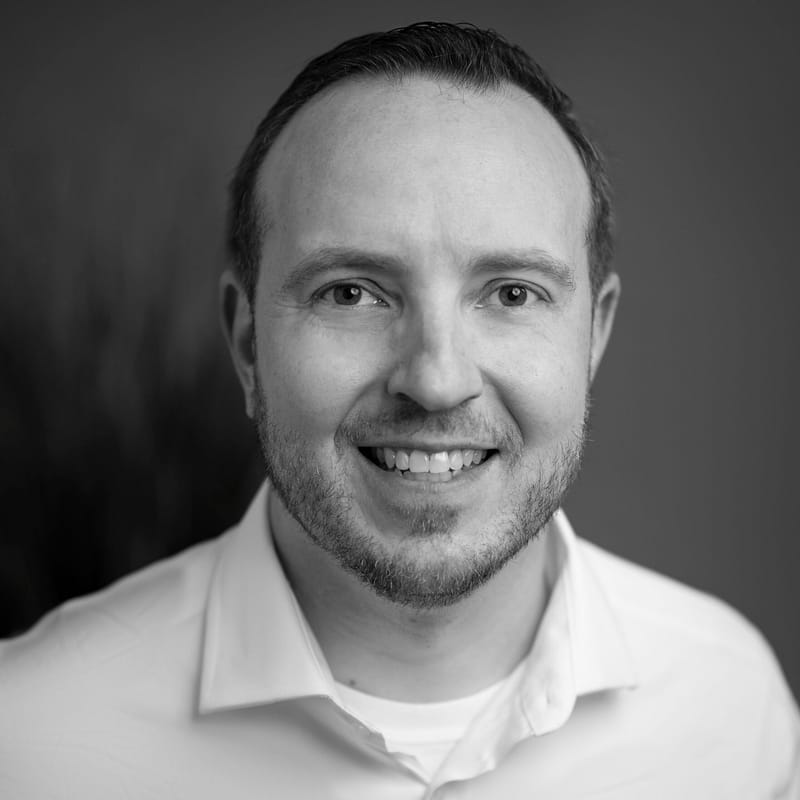 Dennis Johnson's headshot in black and white in office space.