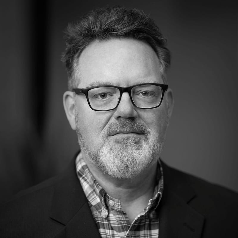 Ian Solomon's Headshot in black and white in office space.