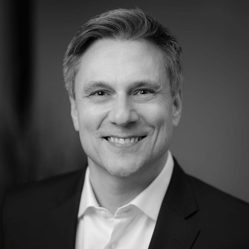 Joe Hutchinson's Headshot in black and white in office space.