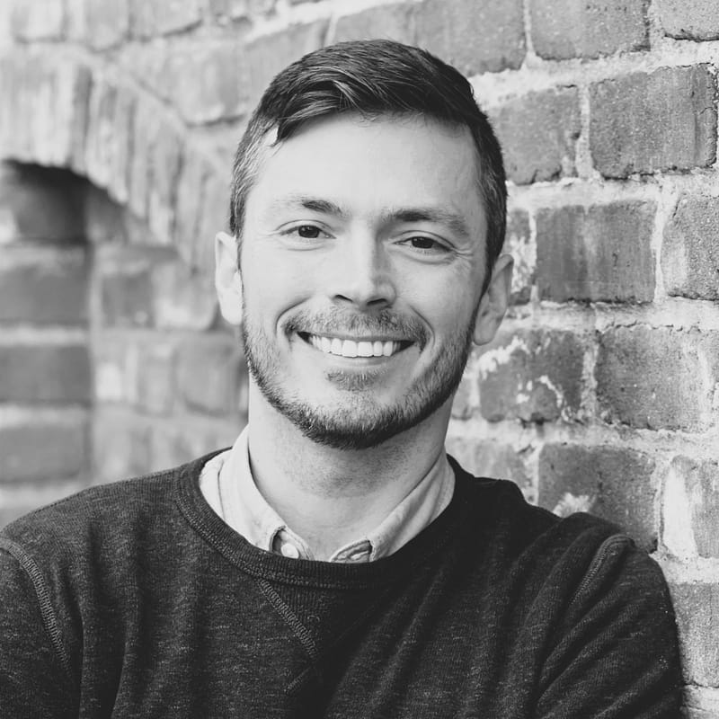 Wes Vahscholtz's headshot in black and white in front of brick building.