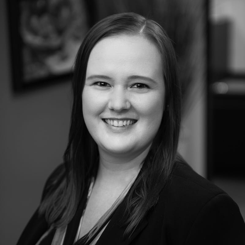 Chelsea McElroy's headshot in black and white in office space.