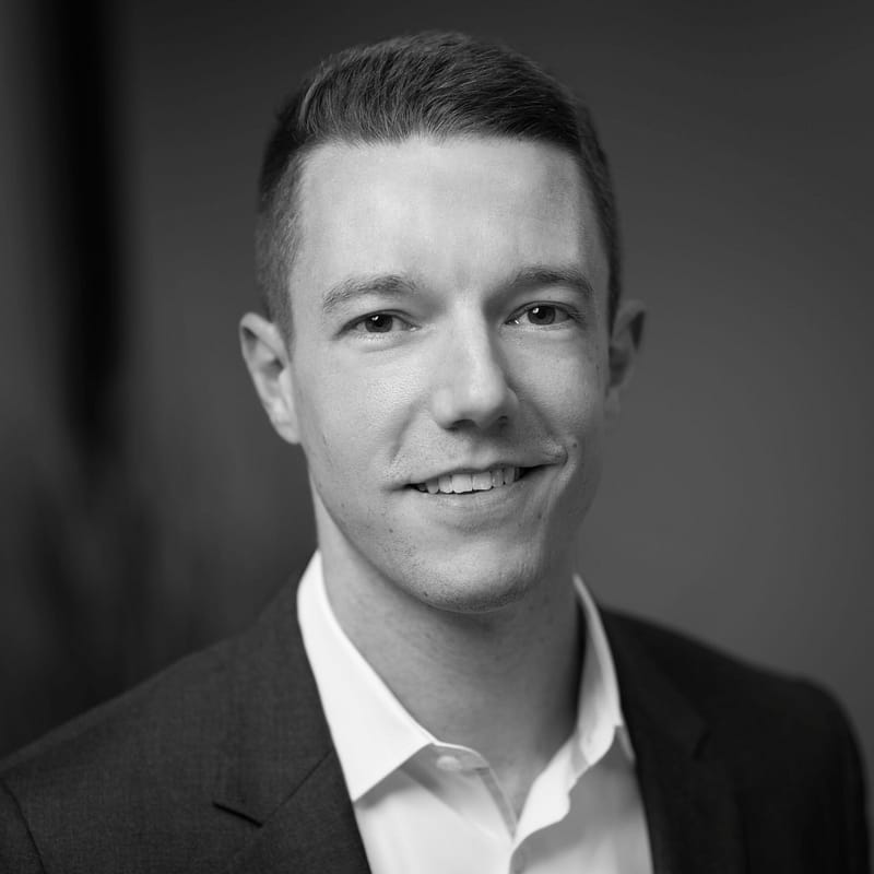 Andrew White's headshot in black and white in office space.