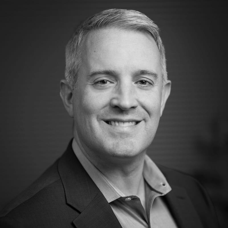 Mark Parson's headshot in black and white in office space.