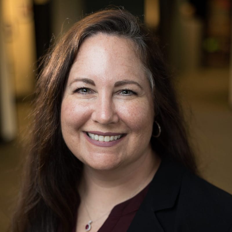 Diana Strassmaier's headshot in full color in office space.