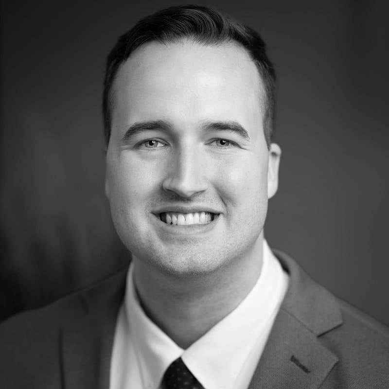 Henry Fillmore's headshot in black and white in a office space at Aldrich CPA + Advisors, where he provides audit/assurance services to clients in the communications and utilities industries.